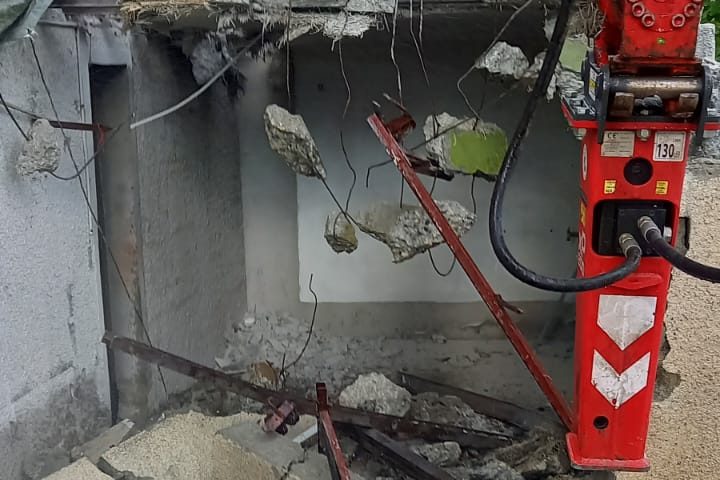 Démolition d'un mur en béton armé au marteau brise-roche